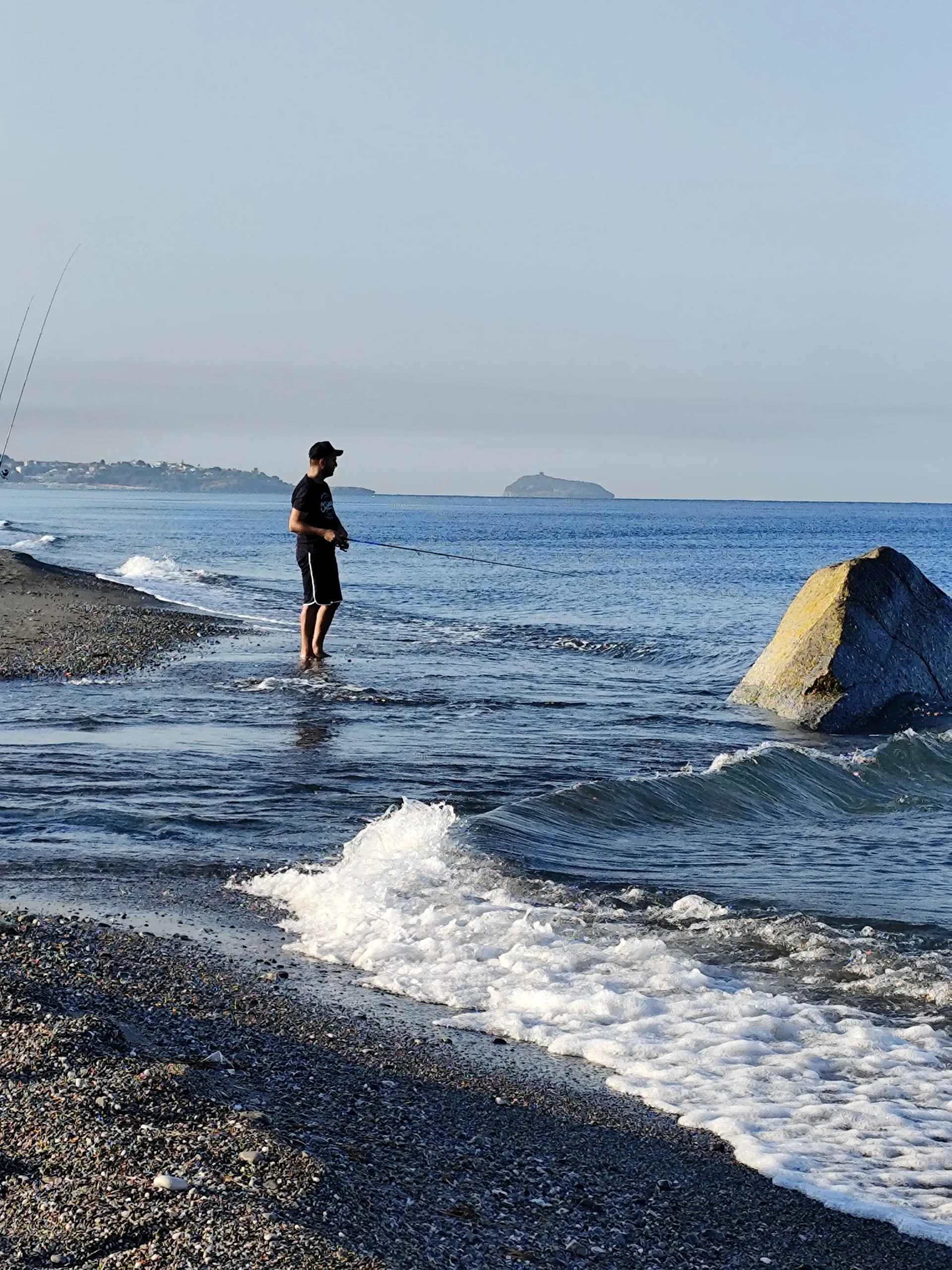 Pescatore in spinning sulla riva della foce del Lao a Scalea